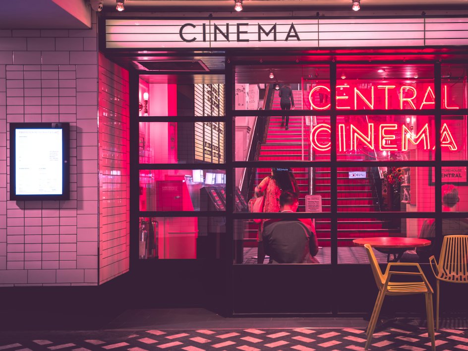 The neon-lit entrance of an independent cinema