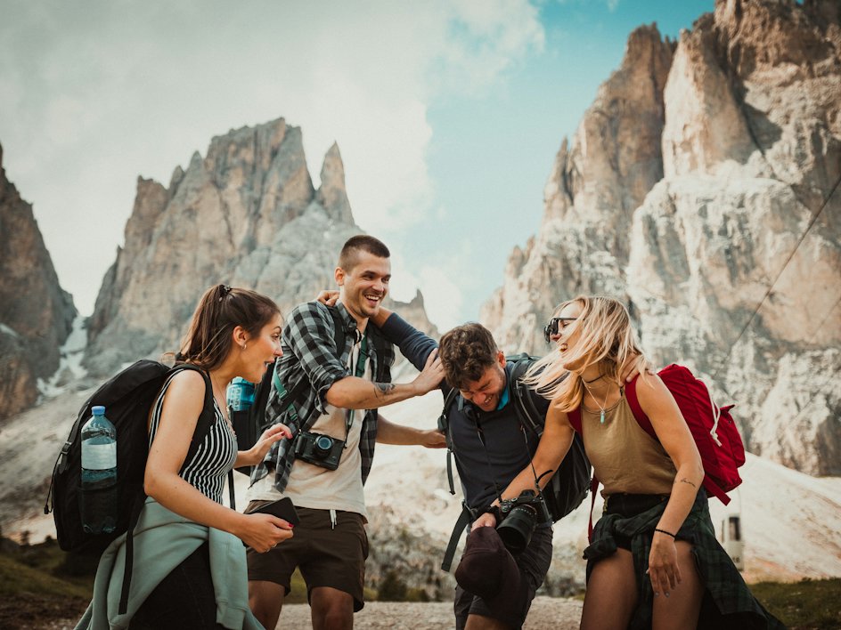 Friends laughing together on a sunny mountain hike